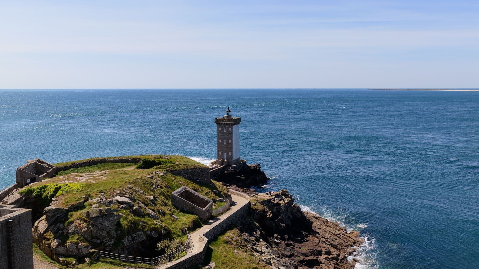 Phare en pierre sur un promontoire rocheux face à la mer