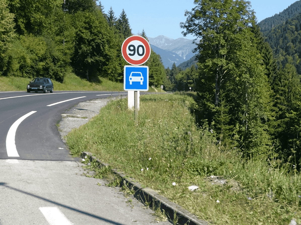 Une voiture circule sur une route de montagne.