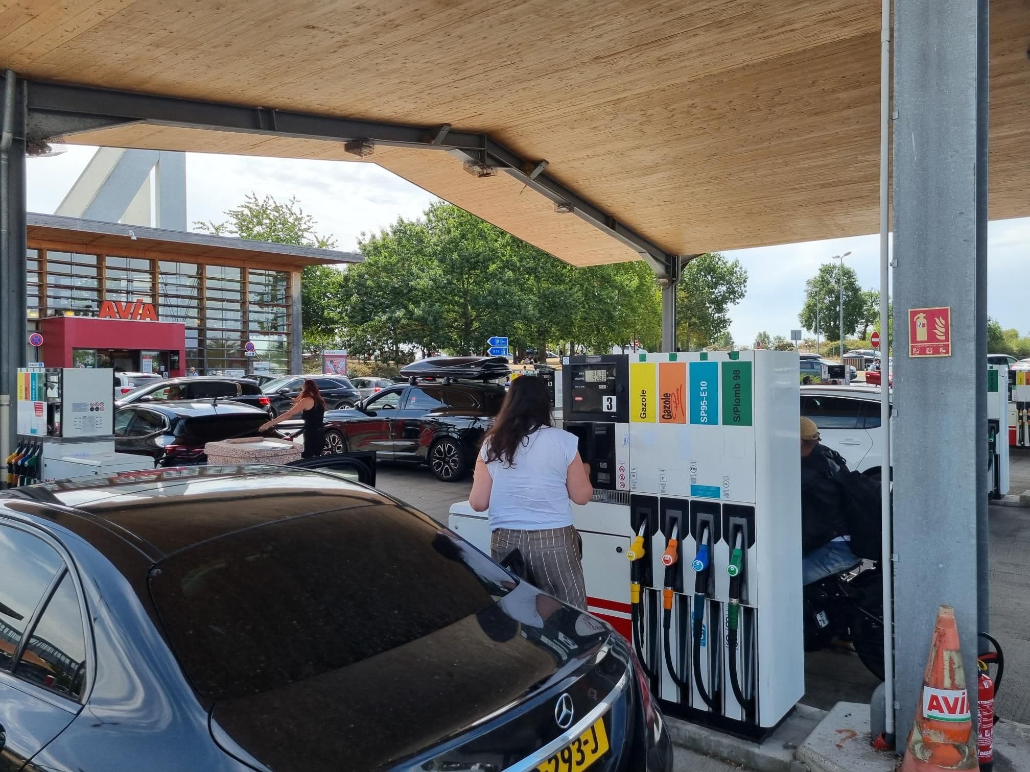 Une femme fait son plein dans une station service.