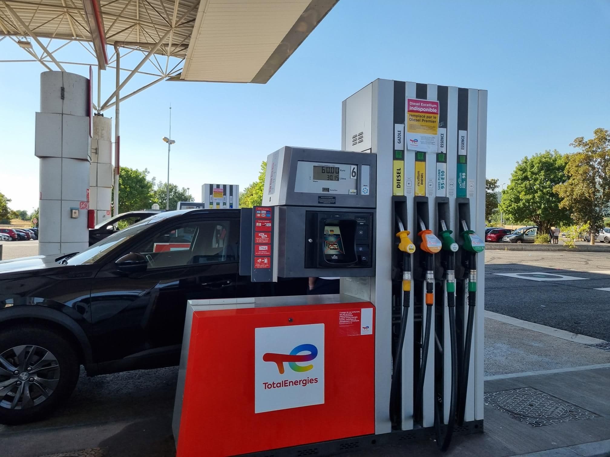 Pompe TotalEnergies affichant 60 euros de carburant et un véhicule noir