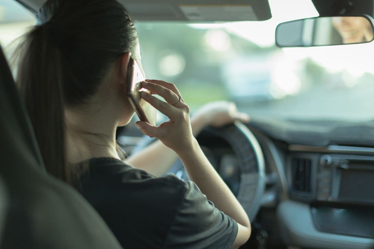 Conductrice au volant utilisant son téléphone en conduisant