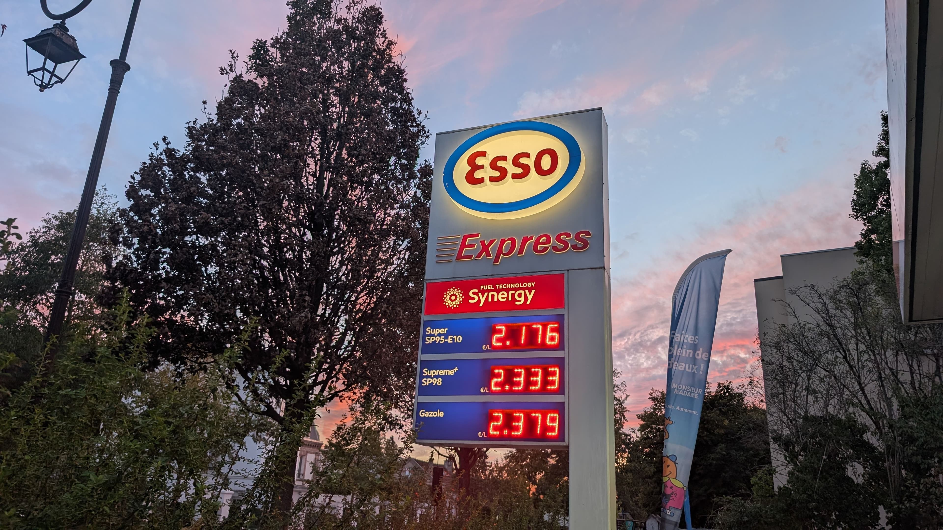 Panneau Esso Express affichant les prix du carburant au crépuscule