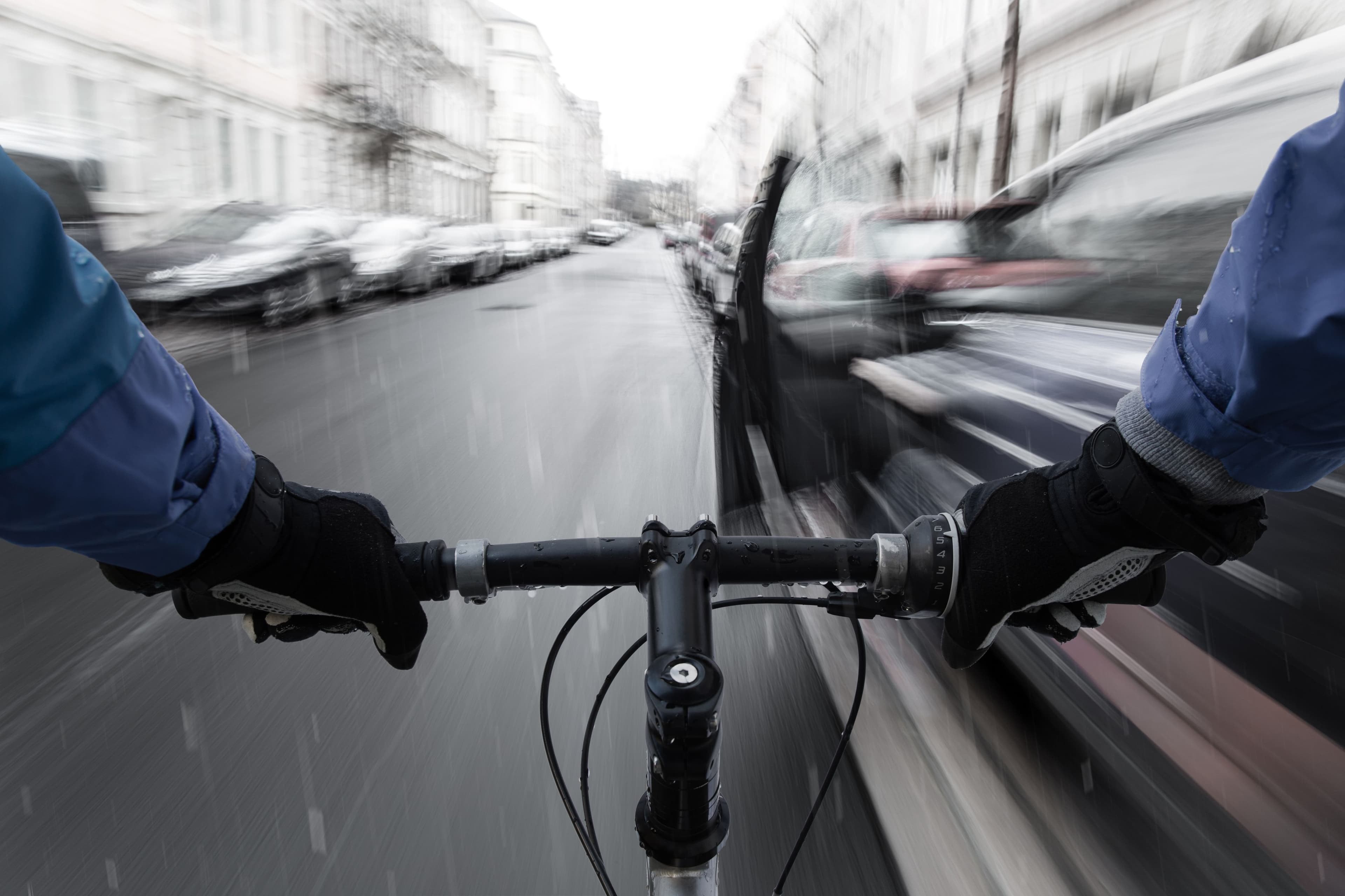 Un vélo risquant de percuter une portière de voiture.