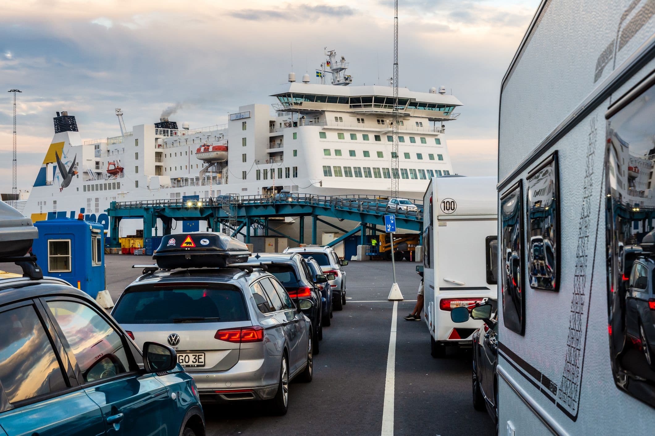 Files de voitures et camping-cars embarquant sur un ferry à quai