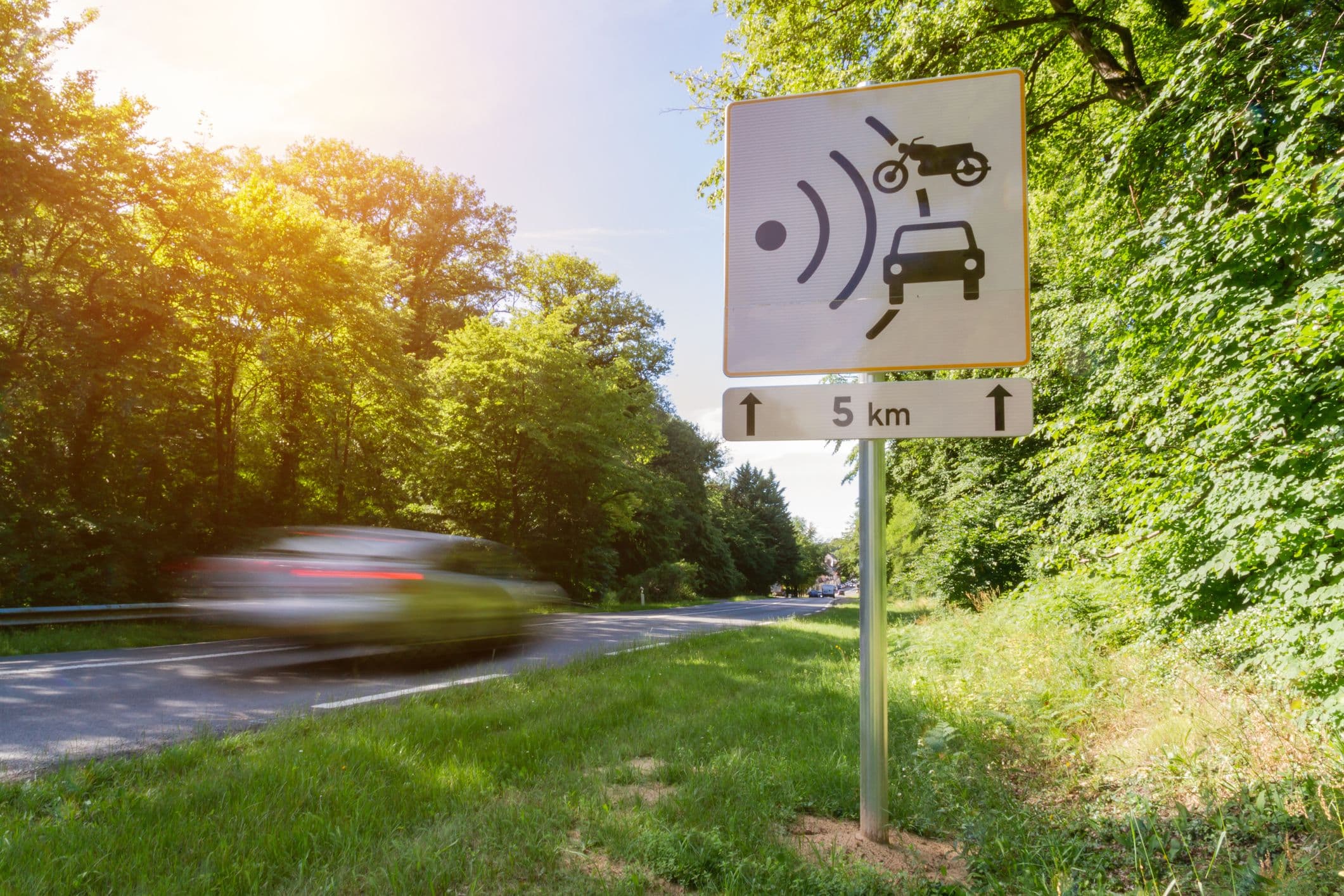 Une voiture roule très vite sur une route où il y a des radars