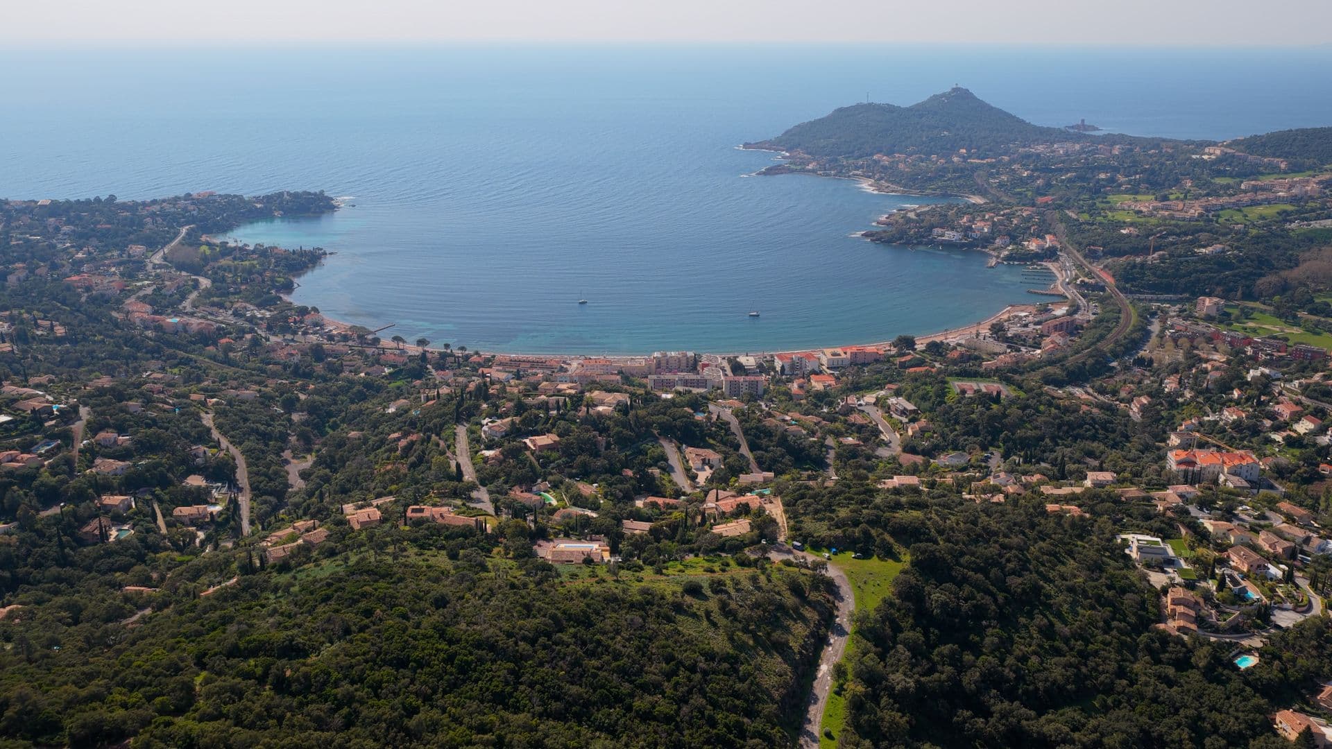 Vue aérienne sur la baie d'Agay avec des collines verdoyante et le bleu de la mer Méditerrane