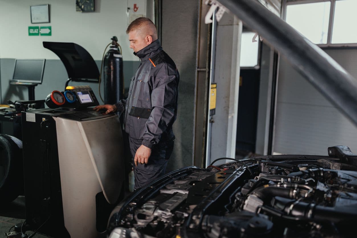 Un homme en train d'effectuer le contrôle technique d'une voiture.