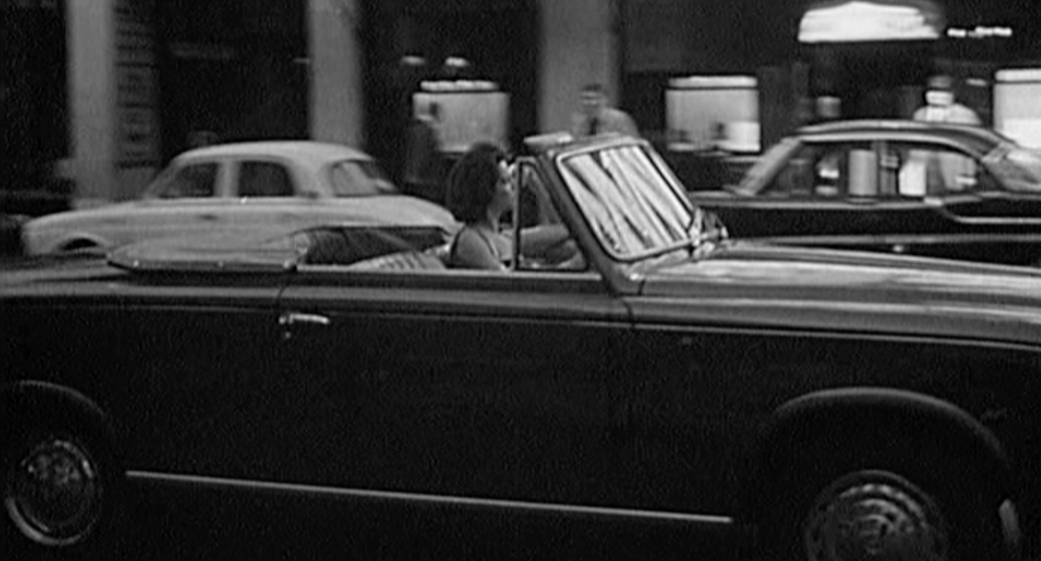 Une femme au volant d'une voiture en 1959 © INA