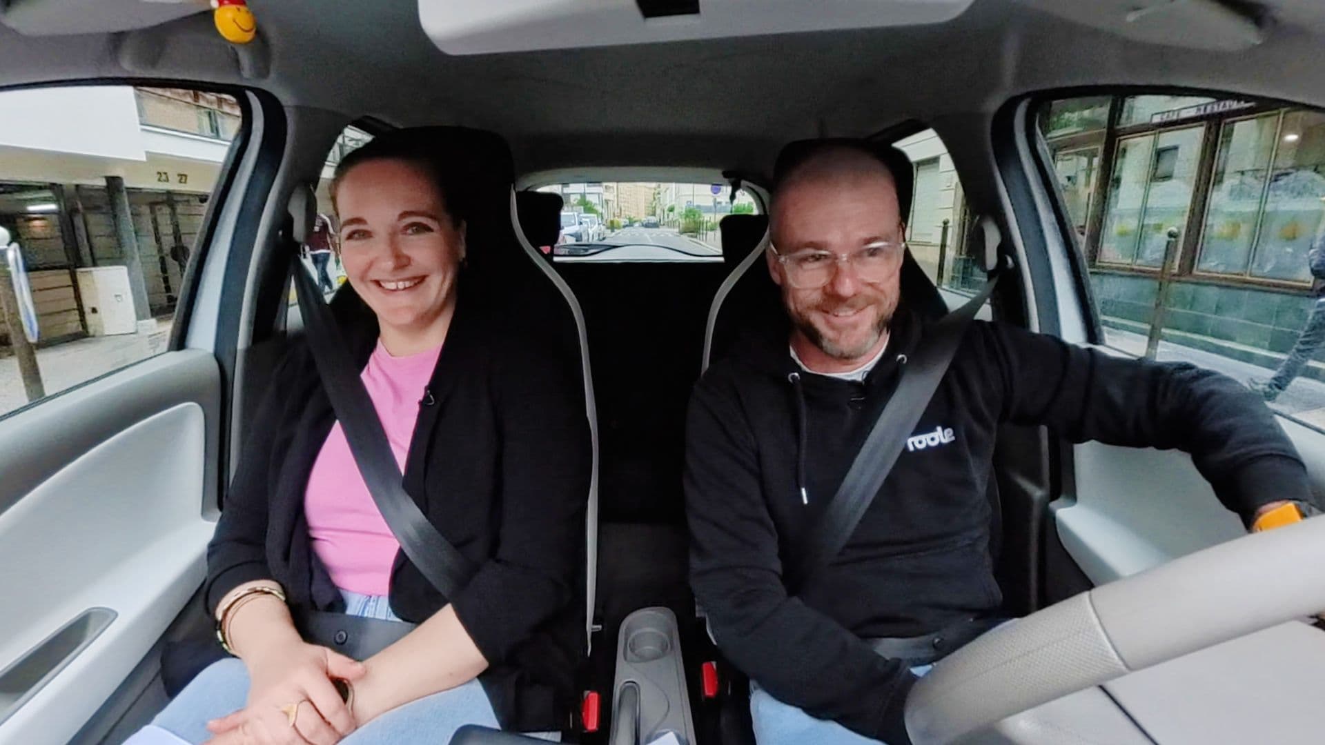 La journaliste Eva Gomez et le directeur général délégué de Roole, Thomas Fournier, assis côte à côte dans l'habitacle d'une Renault Zoe