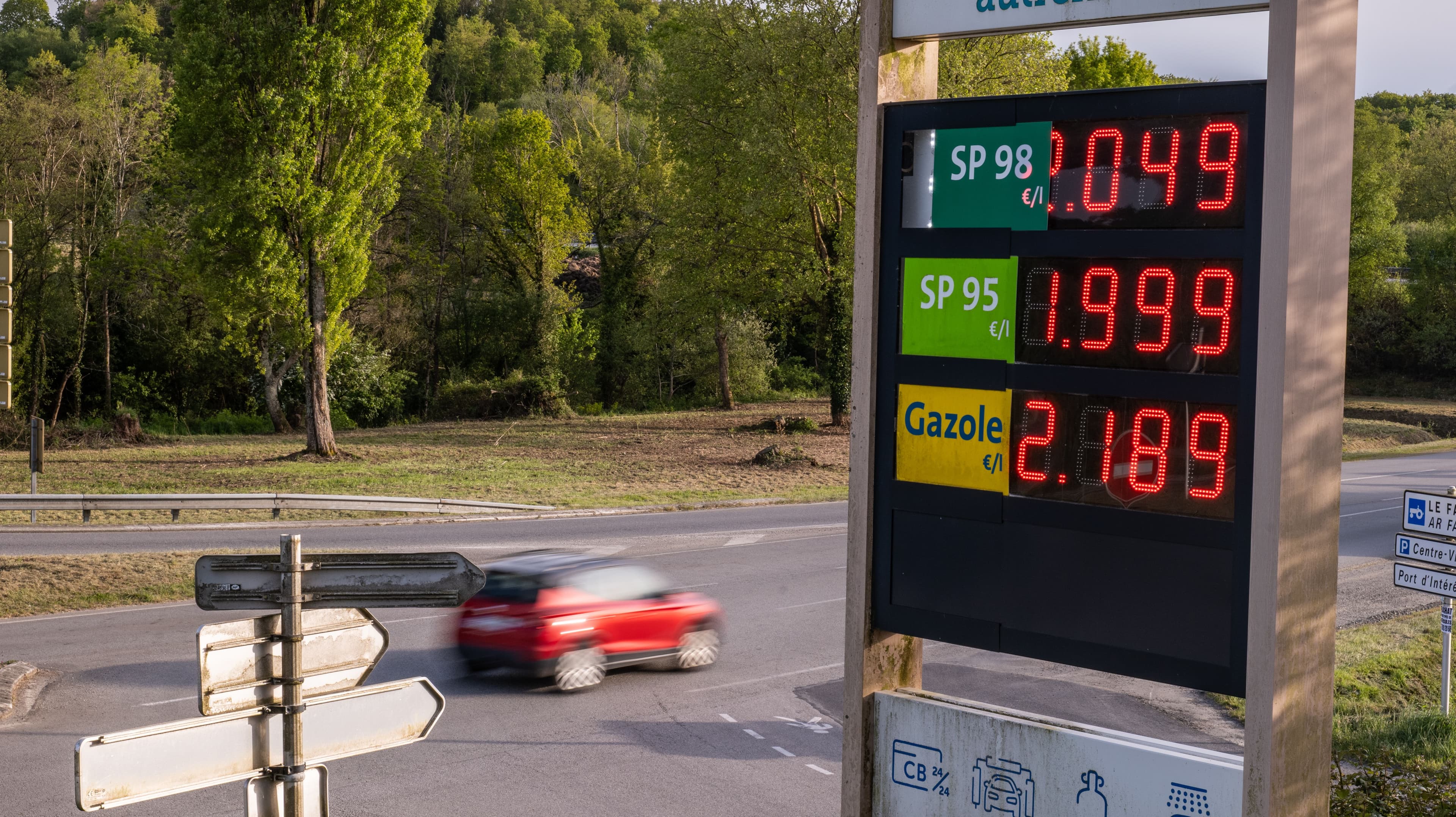 Photo d'un totem devant une station-service affichant les prix des carburants.
