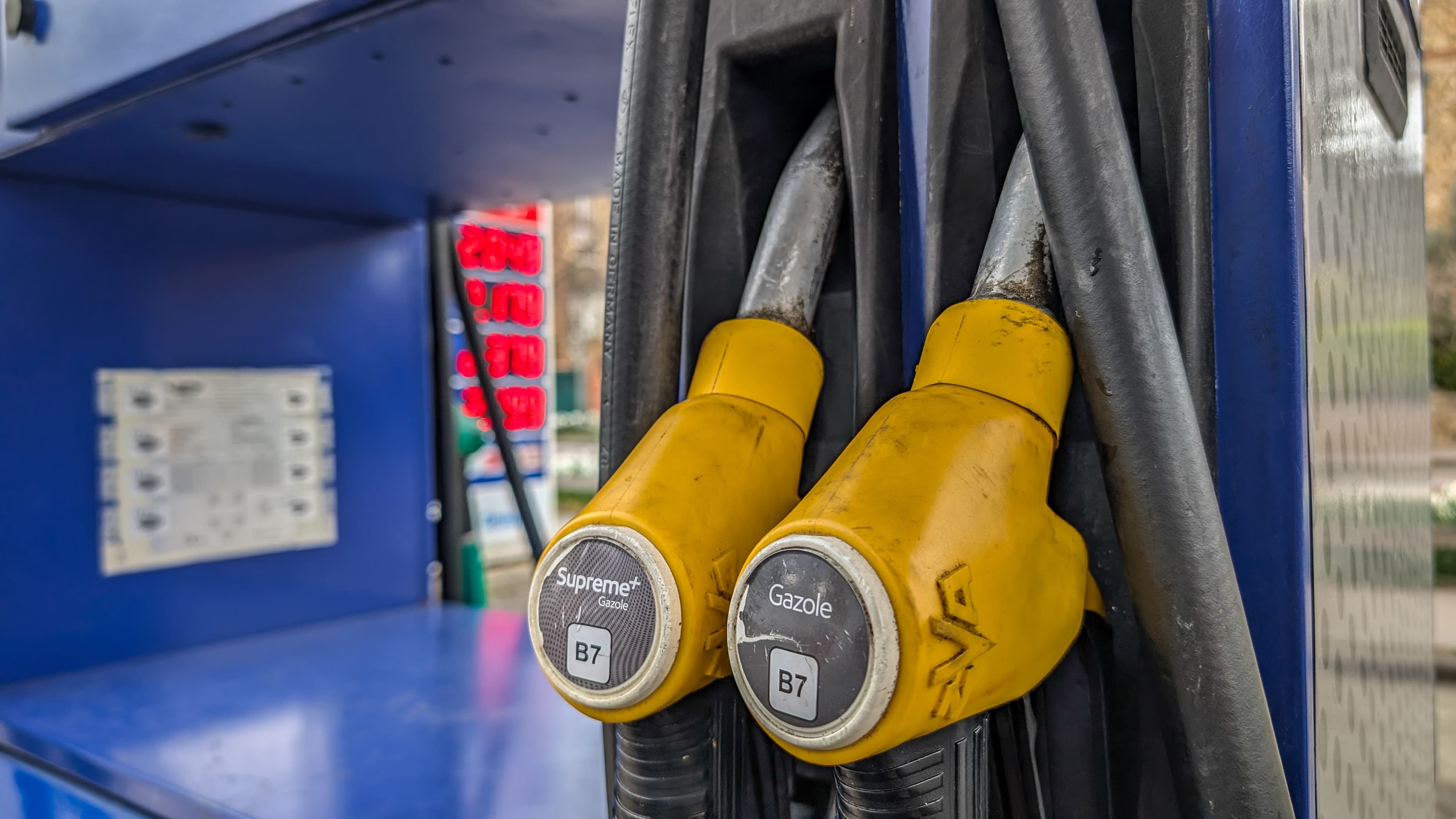 Un zoom sur deux pistolets de gazole dans une station service.