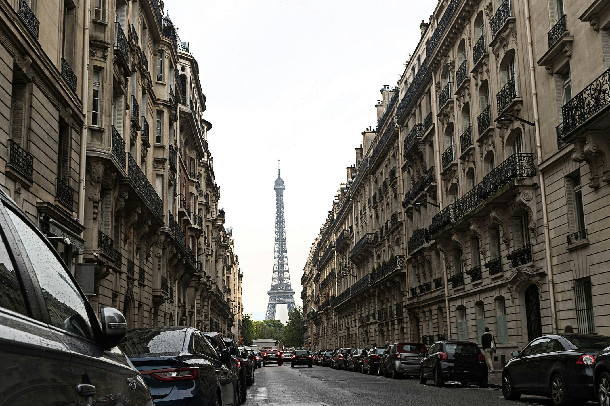 Des voitures garées dans les rues de Paris devant la Tour Eiffel.