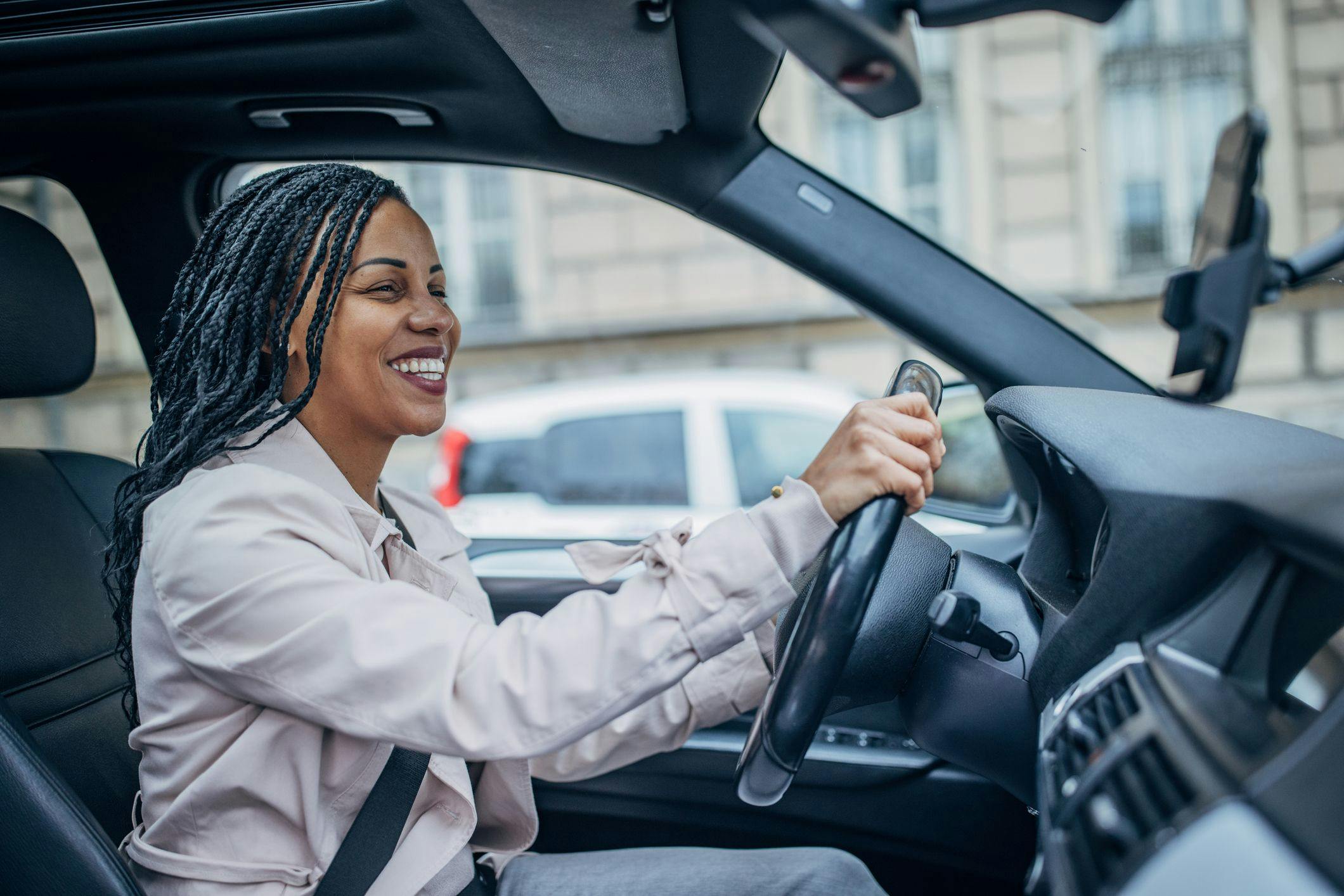 une femme souriante au volant d'une voiture