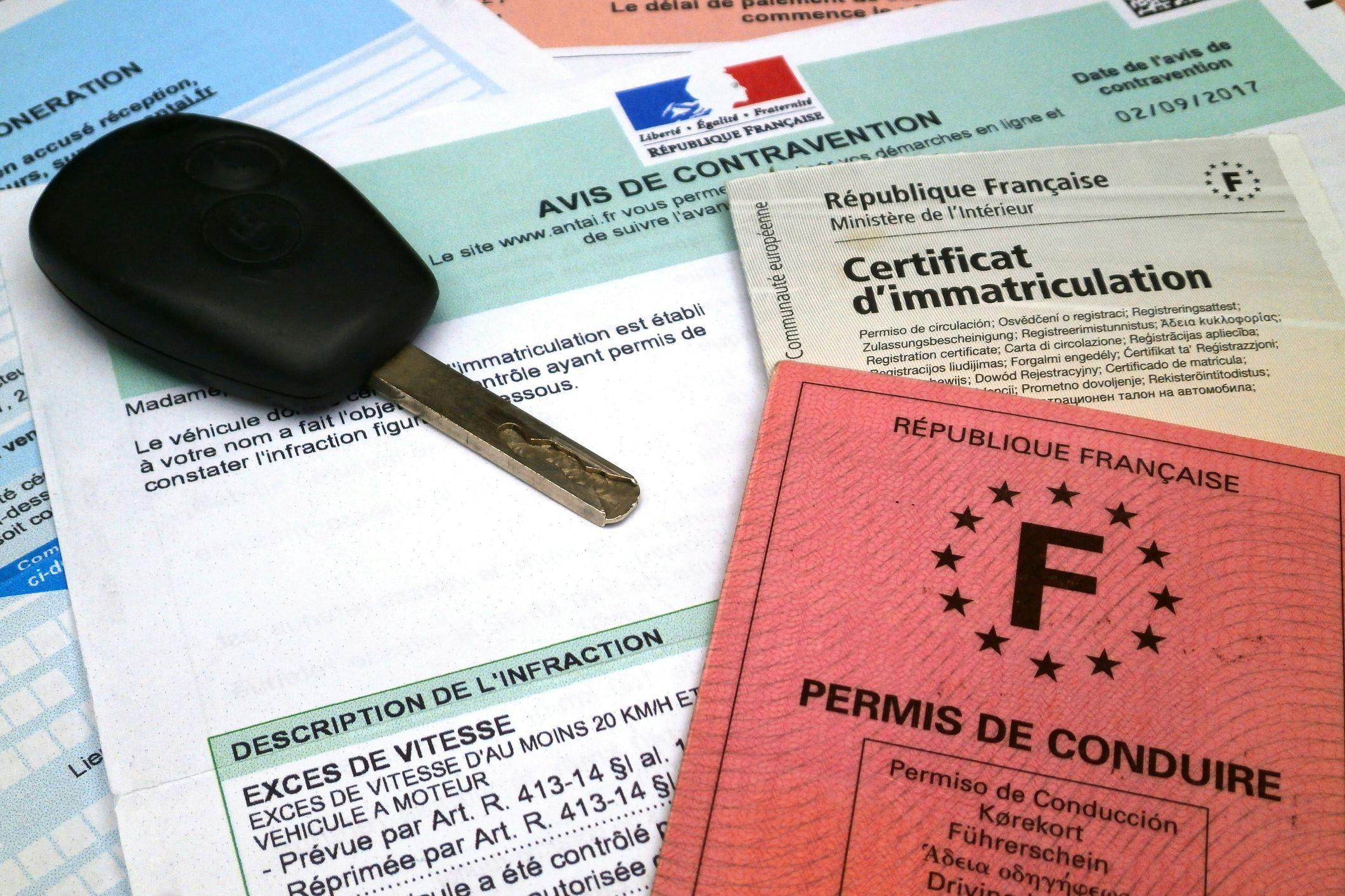 Un avis de contravention avec clé de voiture, permis de conduire et certificat d'immatriculation