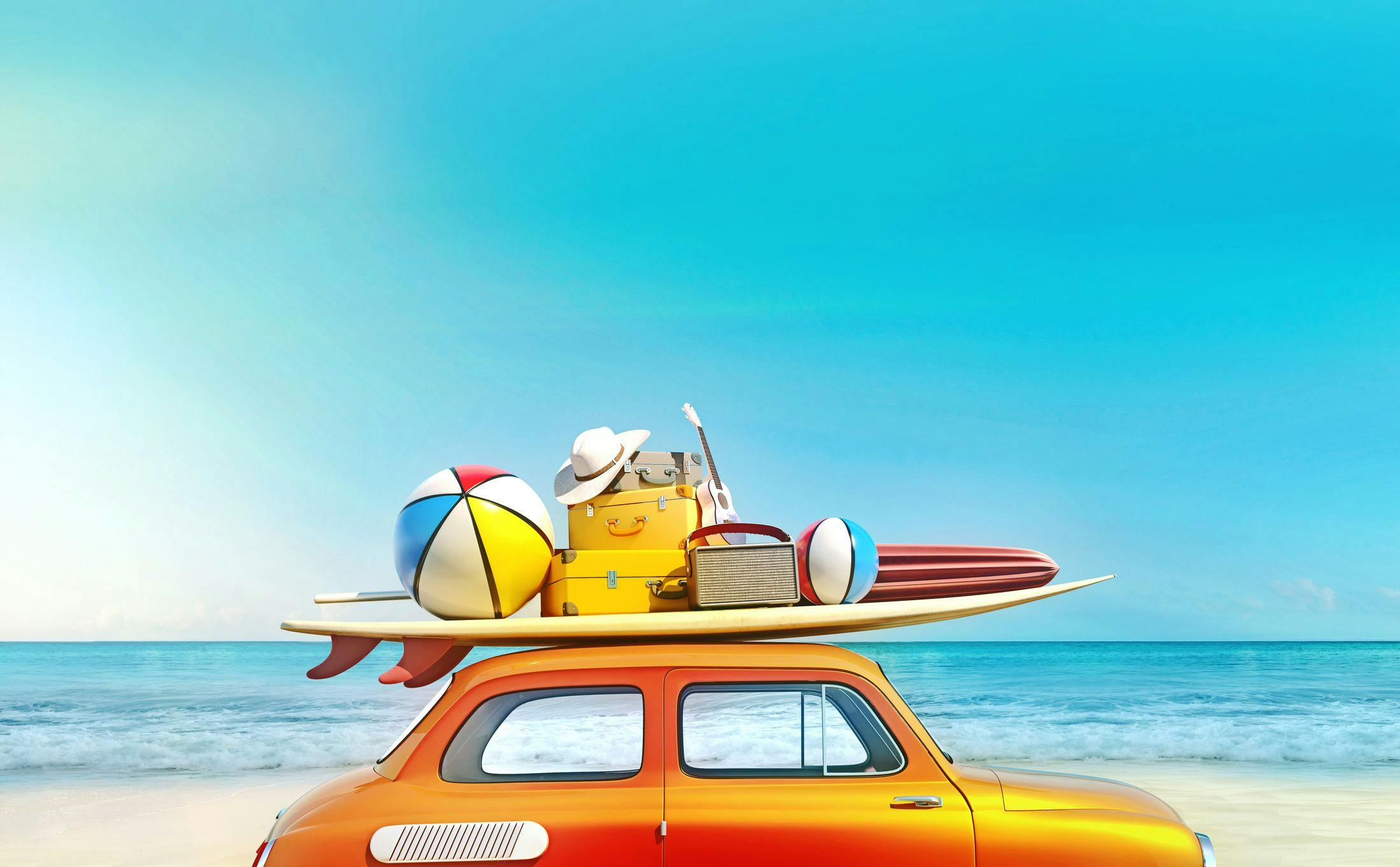Une voiture rétro sur la plage, avec des affaires de vacances sur le toit